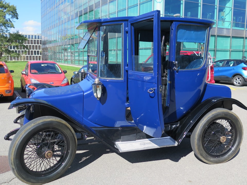 Blauer Oldtimer, der wie eine Pferdekutsche aussieht