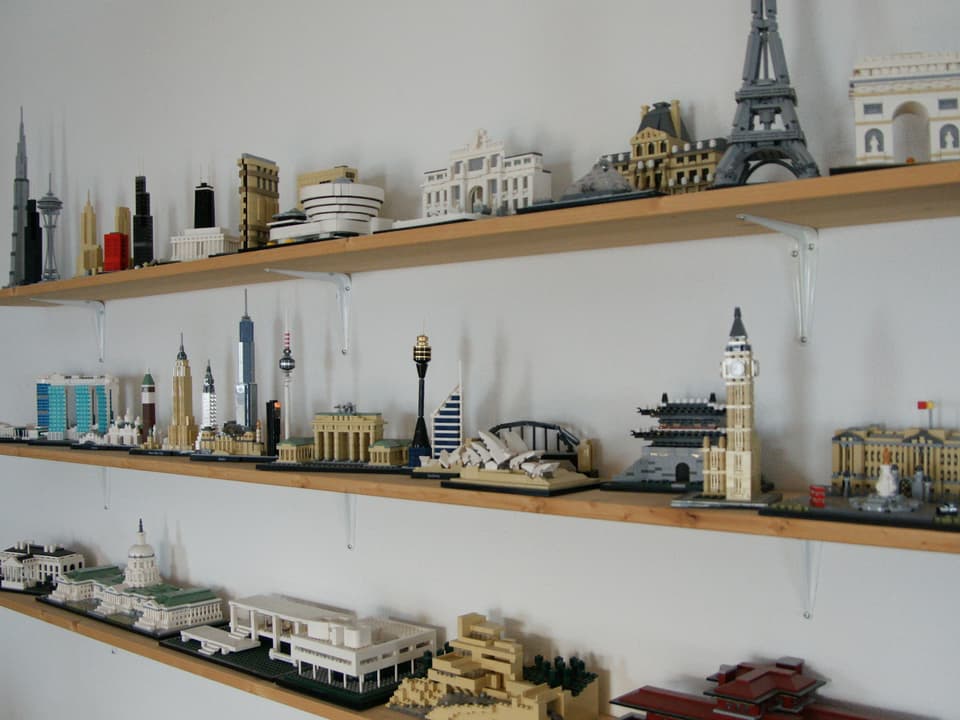 Drei Regalbretter mit Lego-Bauten darauf.