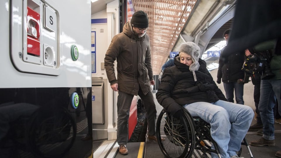 Eine Person im Rollstuhl steigt aus dem Zug aus.