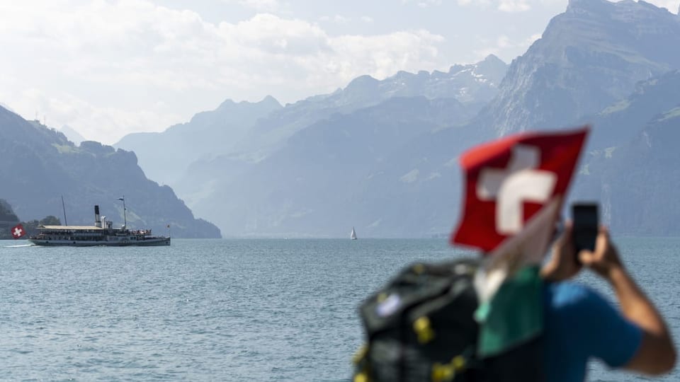 Mensch fotografiert Landschaft auf einem Schiff auf dem Vierwaldstättersee