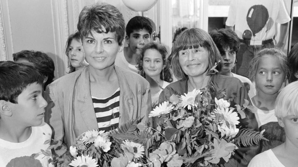 Hanna Johansen und Kaethi Bhend  mit Blumenstrauss umringt von Kindern