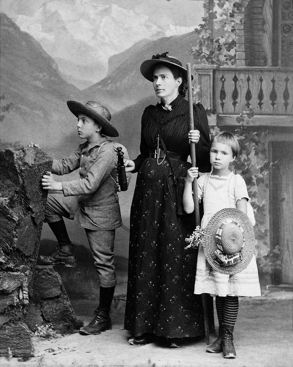 Marie Heim-Vögtlin in einer alten Aufnahme mit ihren zwei Kindern. Alle drei im Bergsteiger-Dress. 