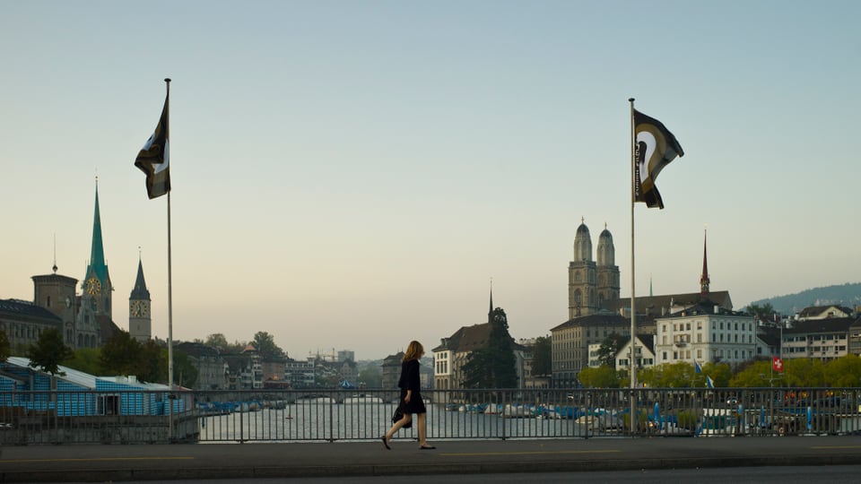 Eine Frau läuft über die Brücke, die Festivalfahnen wehen.