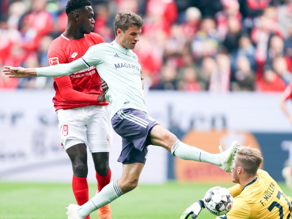 Mainz-Goalie klärt knapp vor dem heranbrausenden Thomas Müller.