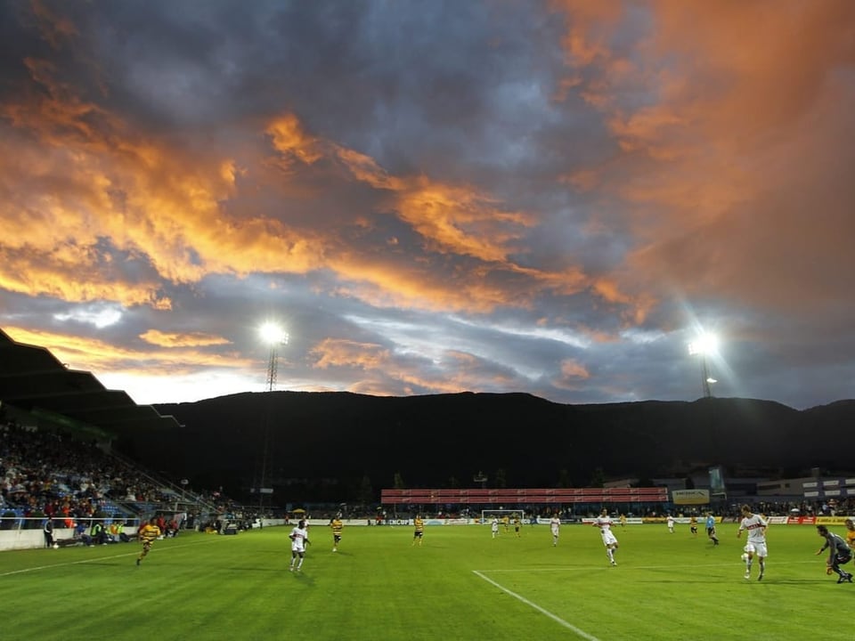 Stadion Brühl mit Fussballern im Vordergrund, Sonnenuntergangsstimmung im Hintergrund