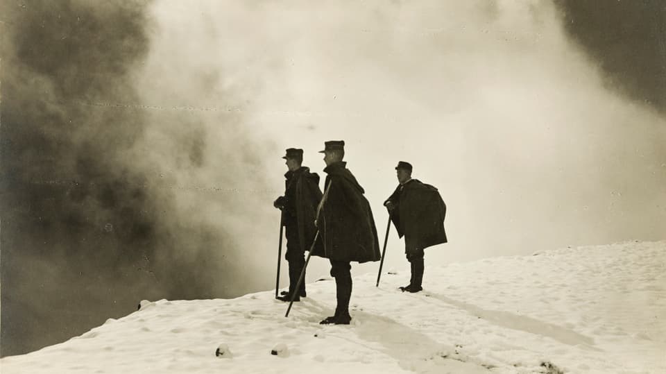Drei Männer stehen auf Schnee.