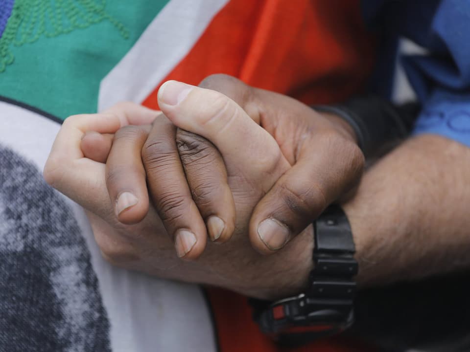 Zwei Hände vereint vor Nationalflagge 