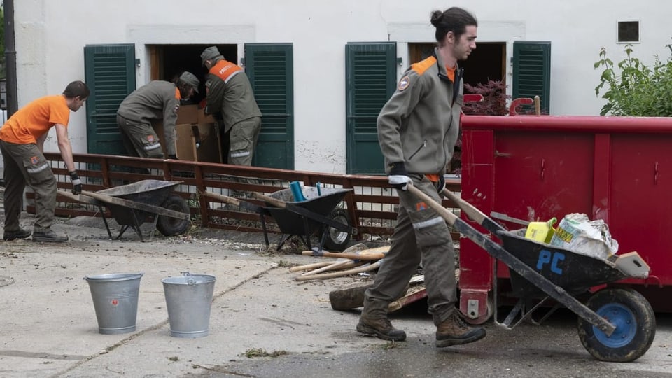 Zivilschützer räumen eine überflutete Wohnung im Berner Jura