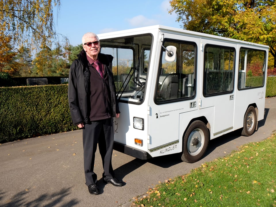 Marc Lüthi steht neben einem weissen Elektrobus.