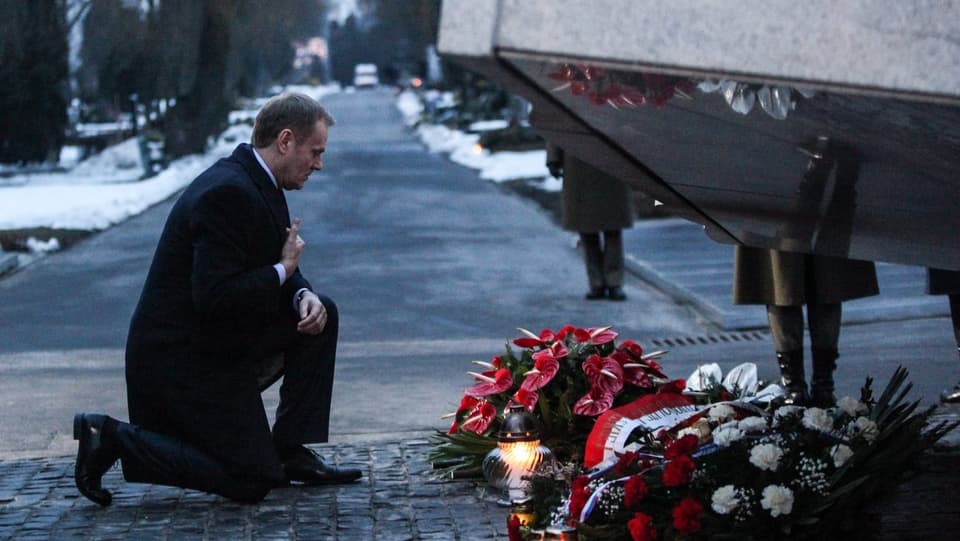 Polens Ministerpräsident Donald Tusk kniet vor einem Denkmal, das zu Ehren der Smolensk-Opfer errichtet wurde