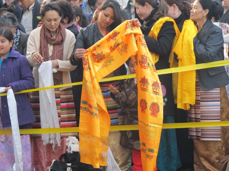 Tibeterinnen halten heilige Schärpen in ihren Händen