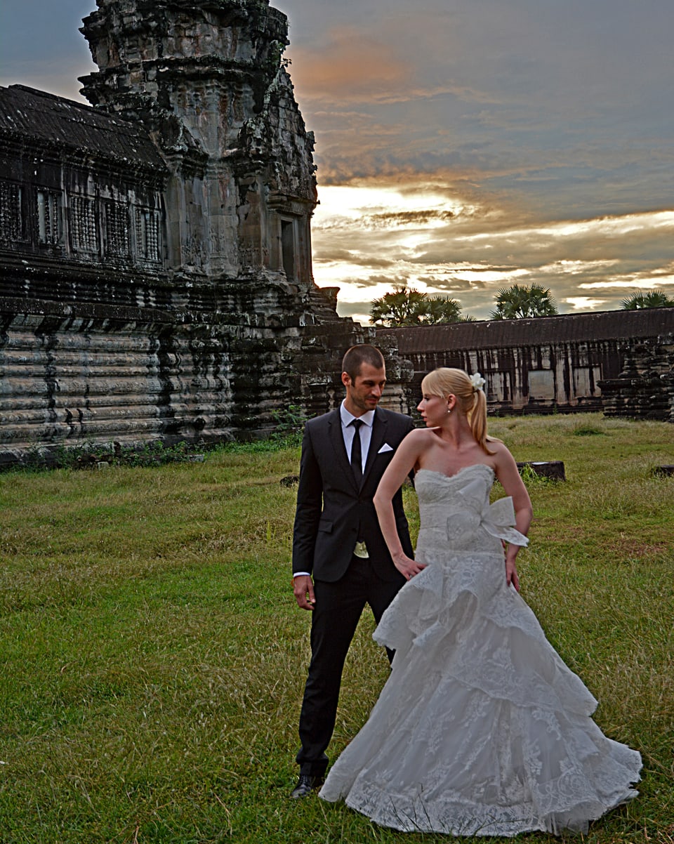 Patrick und Ashley Kerber vor einer alten Tempelanlage in Hochzeitskleidern.
