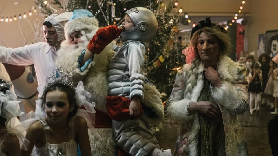 Verkleidete Russen vor dem Weihnachtsbaum: Väterchen Frost hält einen Jungen im sowjetischen Raumanzug in den Armen.