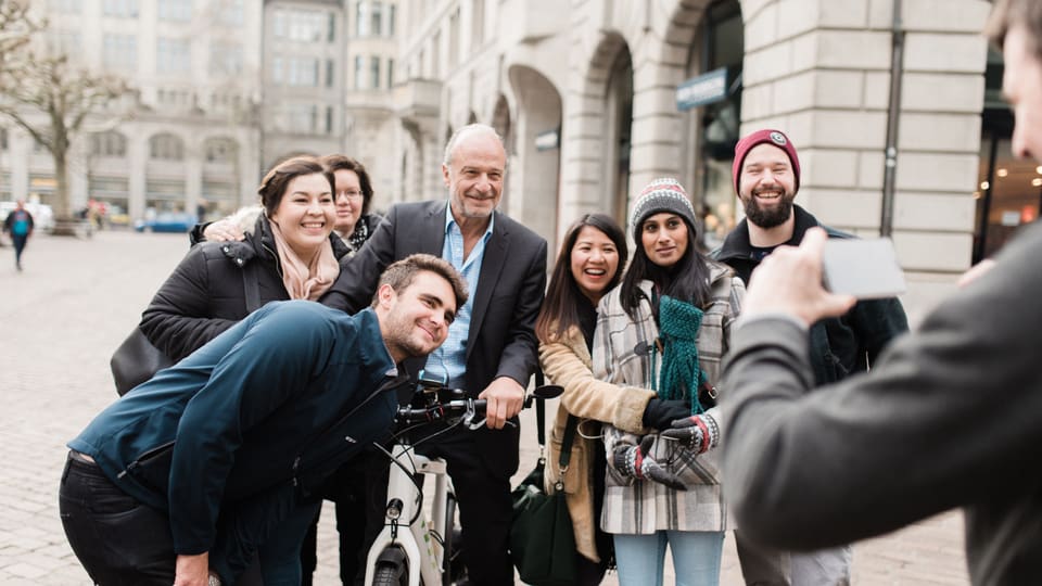 Stadtrat Filippo Leutenegger posiert für ein Foto mit Touristinnen und Touristen.