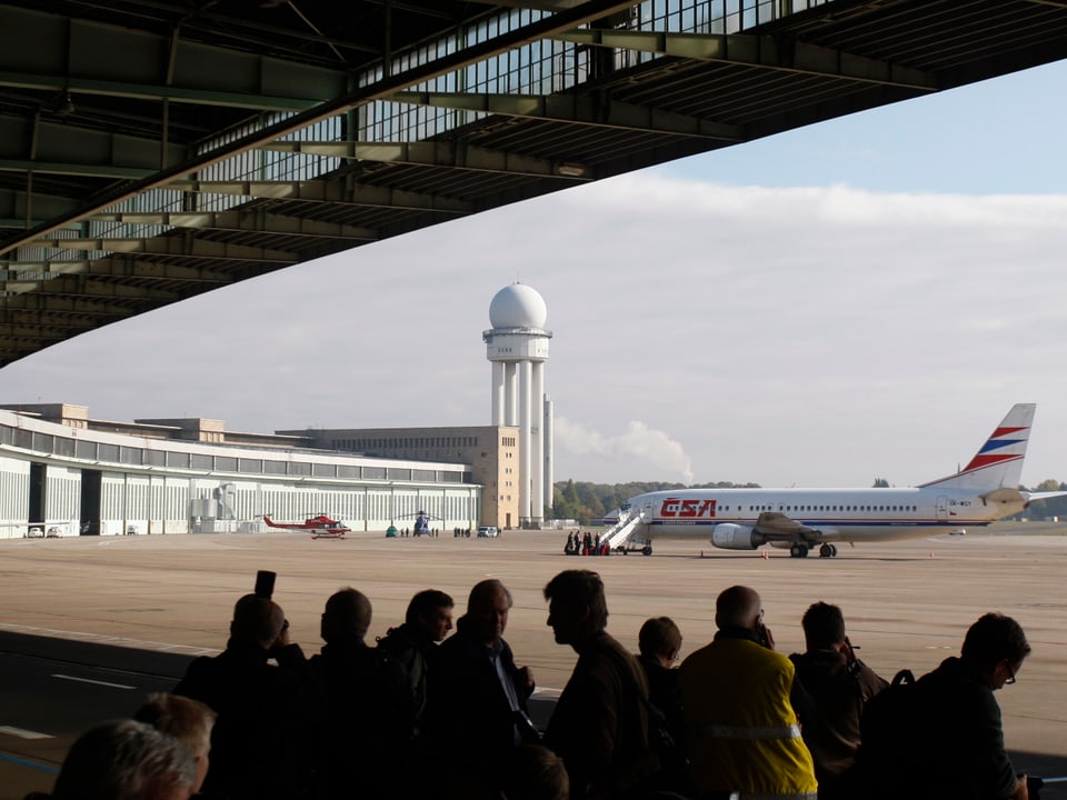 Aufnahme von 2008 aus dem Flughafengebäude heraus auf das Flugfeld, wo eine Passagiermaschine steht.