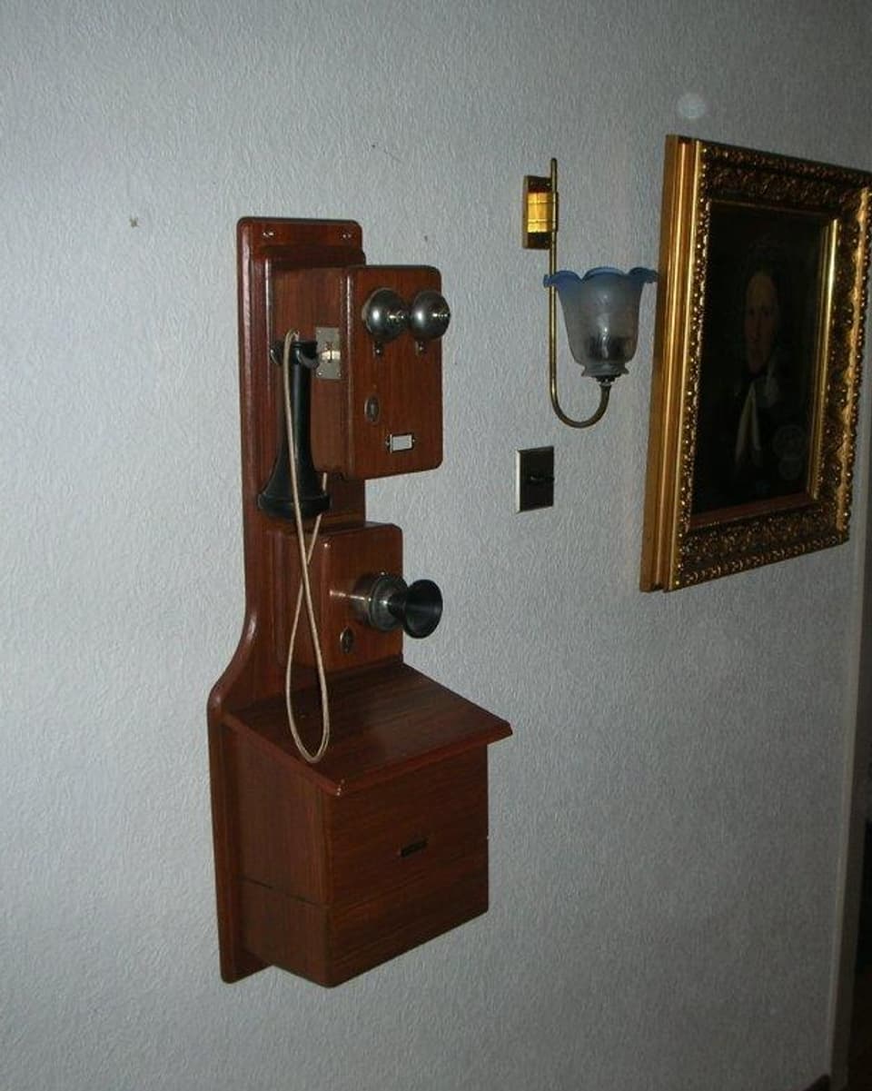 Ein altes Telefon hängt an der Wand.