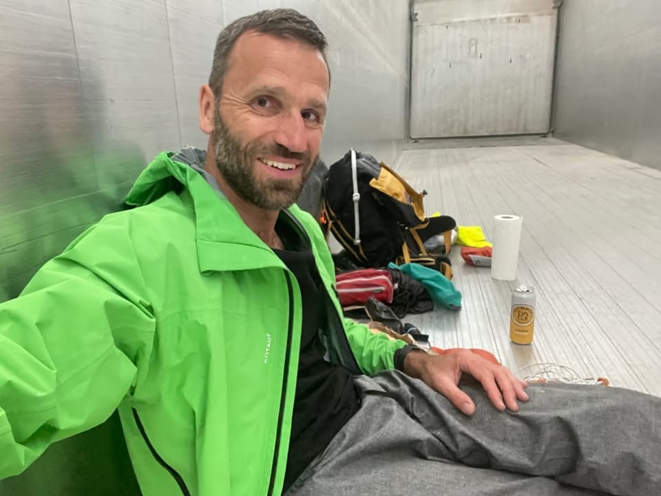 Matthias Rusch sitzt auf der Ladebrücke im Lastwagen.