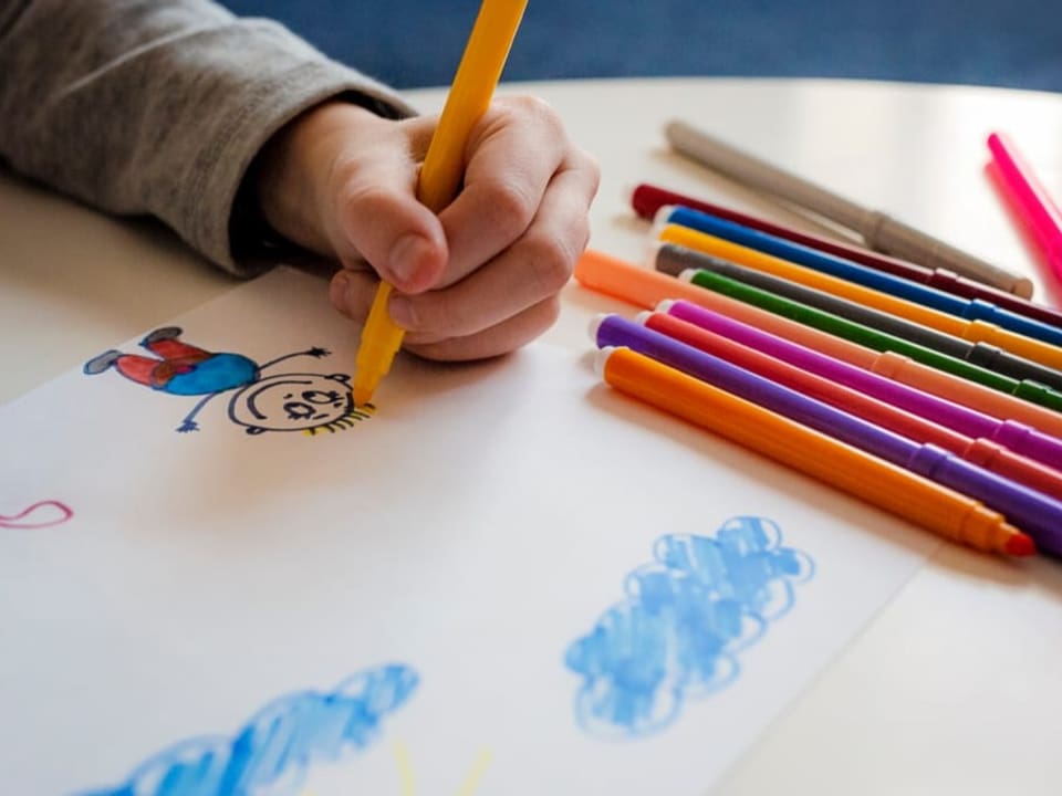 Kind zeichnet mit Links.
