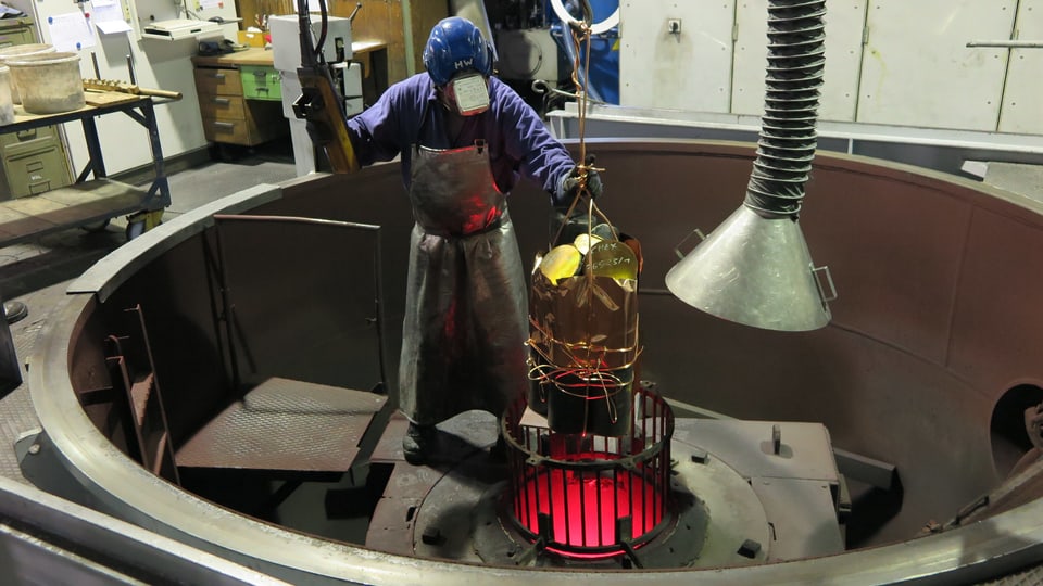 Ein Giesser der Schmelzmetall füllt den Vakuum-Ofen in Gurtnellen mit frischem Kupfer.