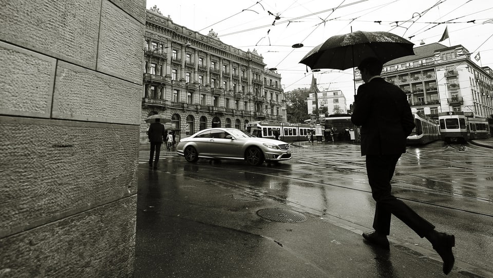 Paradeplatz in Zürich, ein Mann mit Schirm.