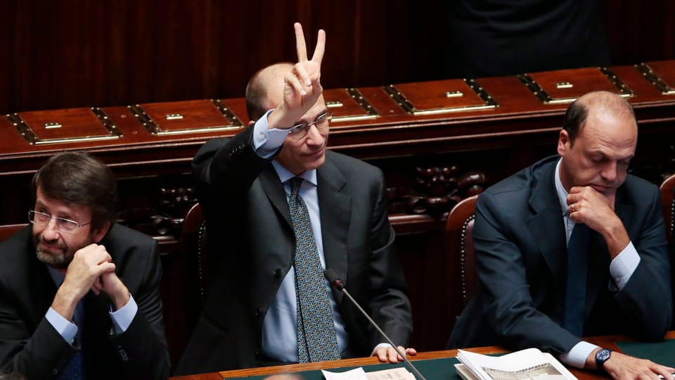 Letta hält im Senat die rechte Hand hoch und zeigt das Victory-Zeichen.