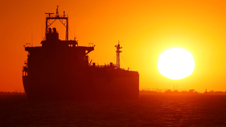 Ein Öltanker auf dem Meer bei Sonnenuntergang.