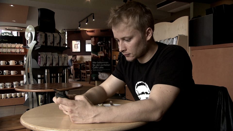 Peponi: Peponi in einem Restaurant mit seinem Handy in der Hand.