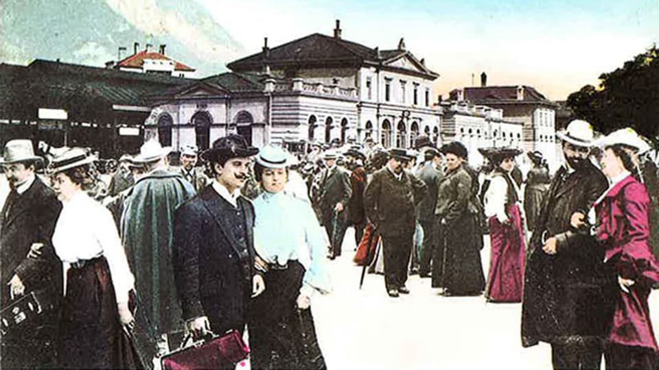 Männer und Frauen auf einem Bahnhofplatz vor 100 Jahren.