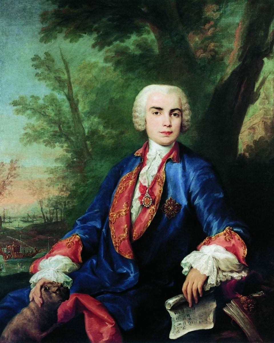 Ein junger Mann trägt eine prächtige Kleidung: einen dunkelblauen Gehrock mit rot-goldenen Verzierungen. In der linken Hand hält er ein Notenblatt.