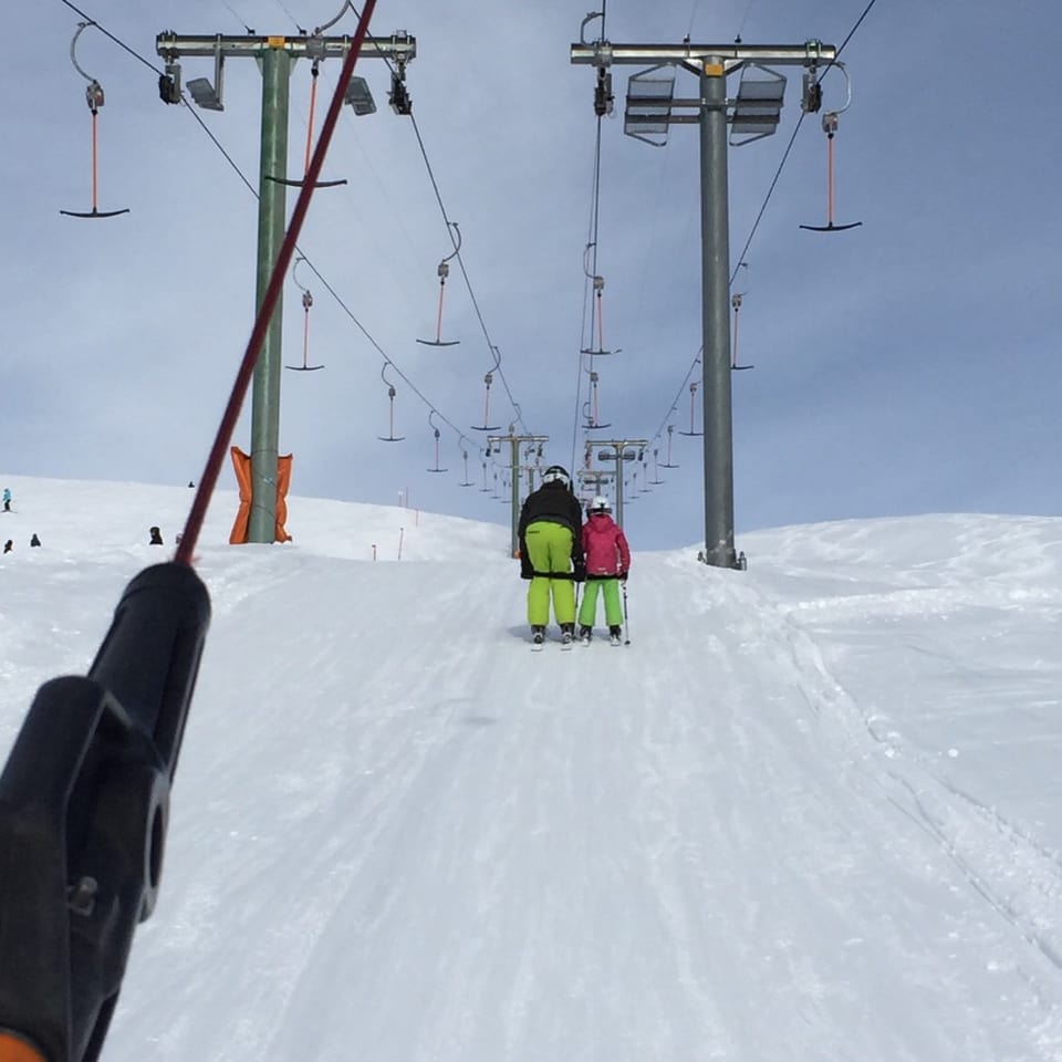 Vater und Tochter beim Skiliftfahren.