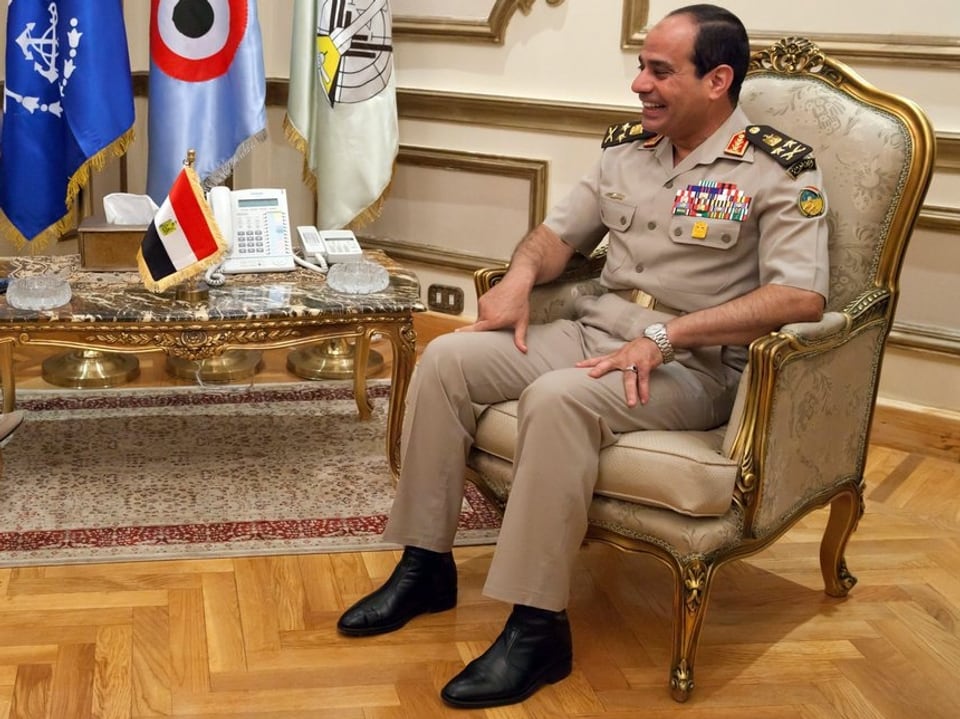 General l Abd Al Fattah Al Sissi während eines Treffens. Er sitzt in einem vornehmen Sessel und lächelt seinen Gesprächspartner an. 
