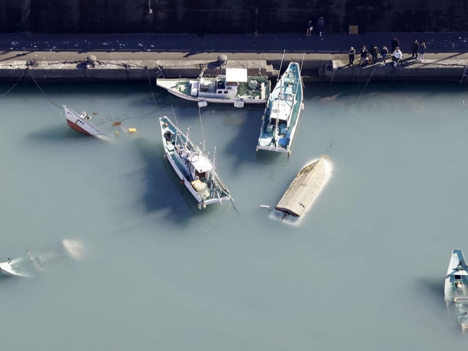 Versunkene Boote treiben im Wasser.