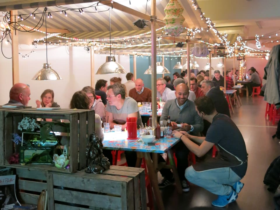 Restaurantbesucher essen im Brother Frank an Marktständen