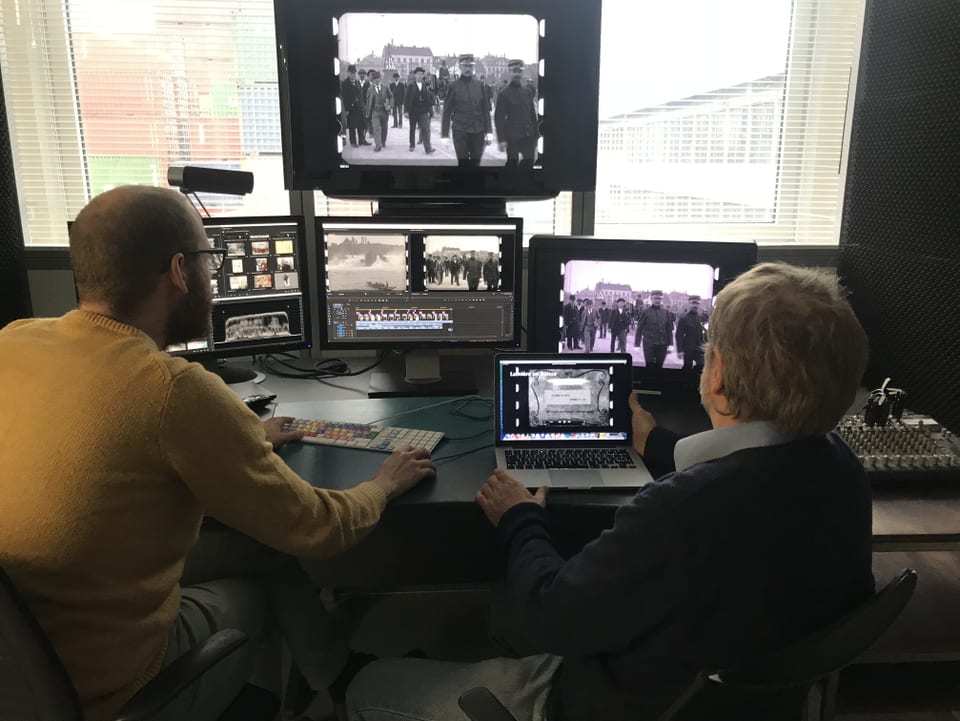 Hansmartin Siegrist und Andreas Weber sitzen vor mehreren Bildschirmen, auf denen man den Film sieht. 
