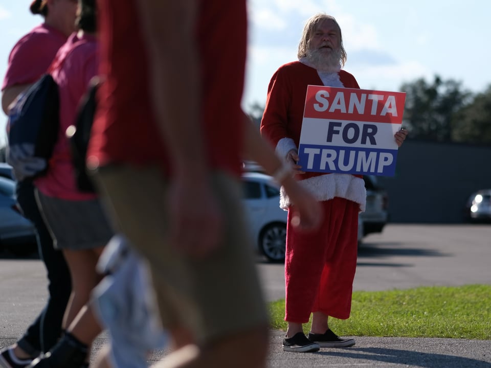 Ein als Samichlaus verkleiderter Trump Supporter mit einem Schild Santas for Trump.