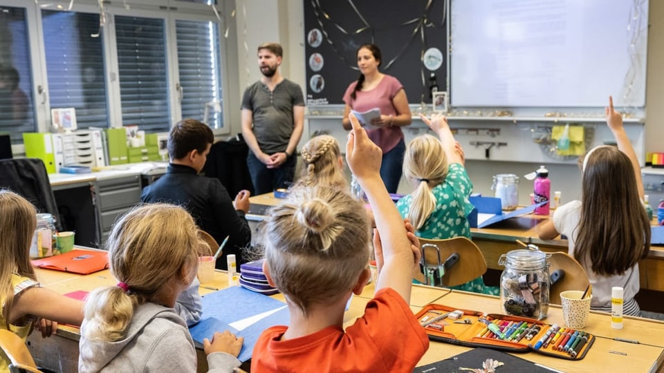 Zwei Lehrer stehen vor einer Klasse