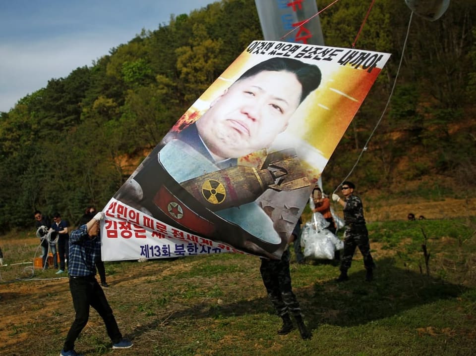 People release balloons with posters in the air.