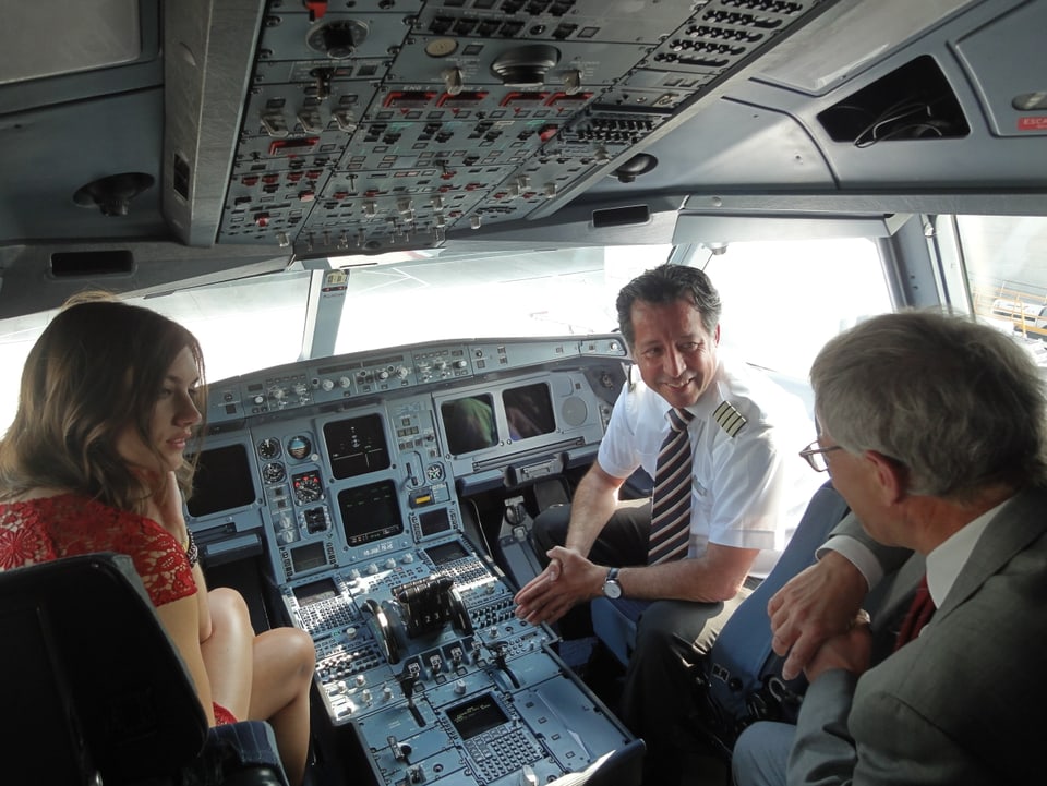 Ronja Furrer, ein SWISS-Pilot und Kurt Fluri im Cockpit des Flugzeugs.