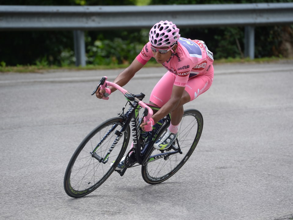 Nairo Quintana fährt im rosa Leadertrikot in eine links Kurve.