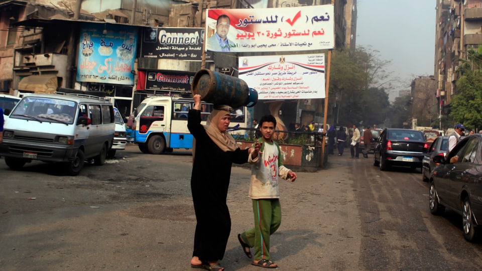 Eine Frau und ein Junge überqueren eine Strasse in Kairo.