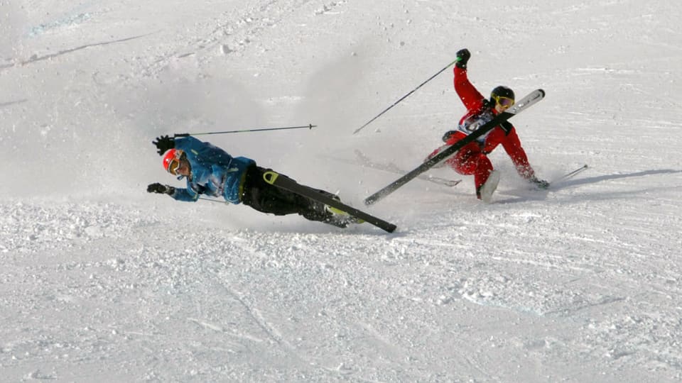 Zwei Skifahrer stossen auf der Skipiste zusammen und stürzen mit hohem Tempo in den Schnee.