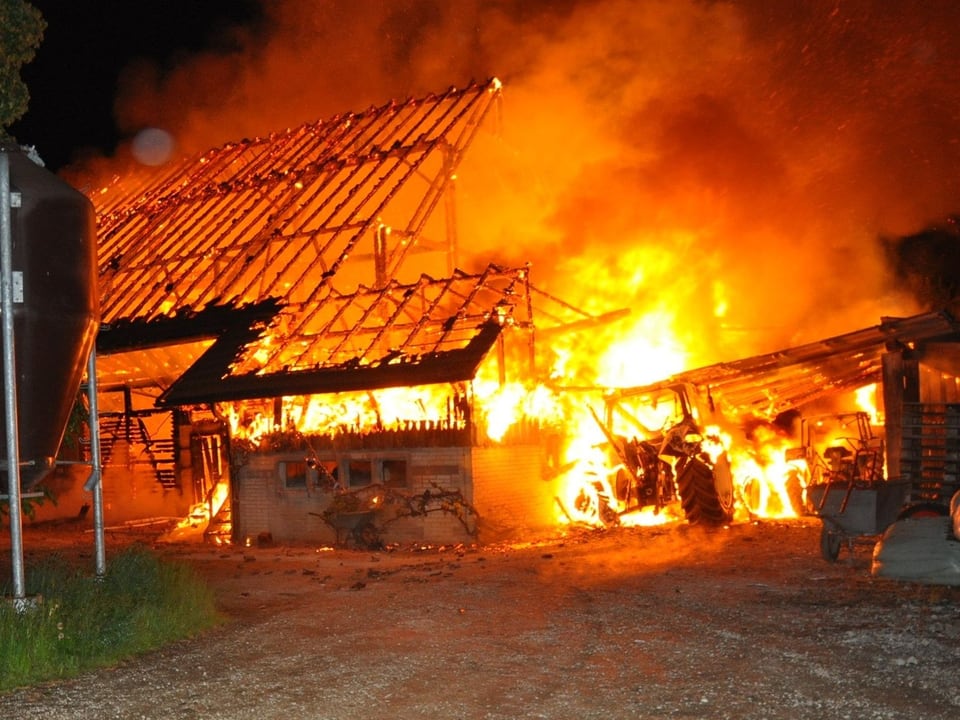 Das Feuer im komplett ausgebrannten Stall flackert lichterloh.
