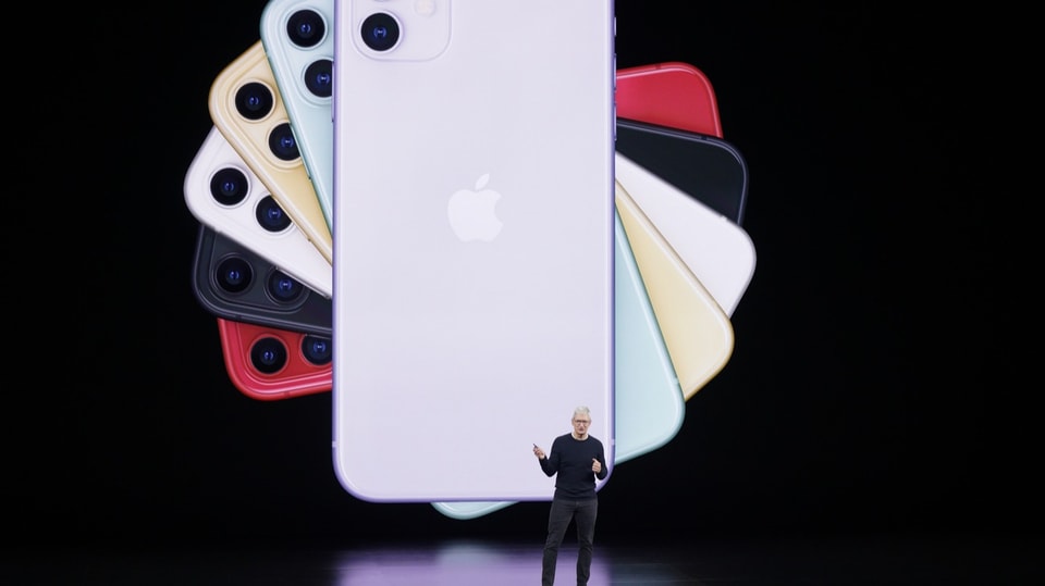 Apple-Chef Tim Cook steht vor einer Leinwand mit farbigen iphones.hone-Präsentation