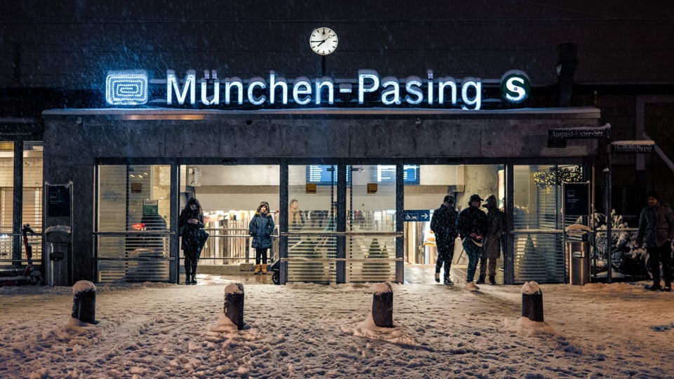 Menschen stehen in der Kälte um den Bahnhof München-Pasing.