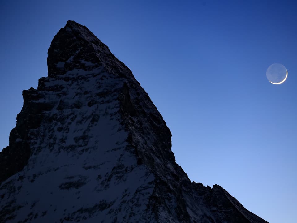 Freier Blick am Abend von Zermatt auf Matterhorn und zunehmende Mondsichel. 