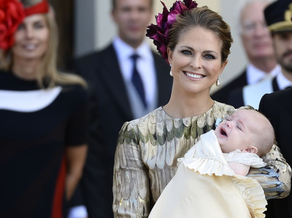 Prinzessin Madeleine ein Baby haltend.