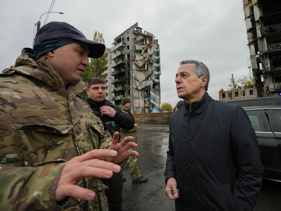 Bundespräsident Ignazio Cassis (rechts) spricht mit einem Mann in Armeebekleidung.