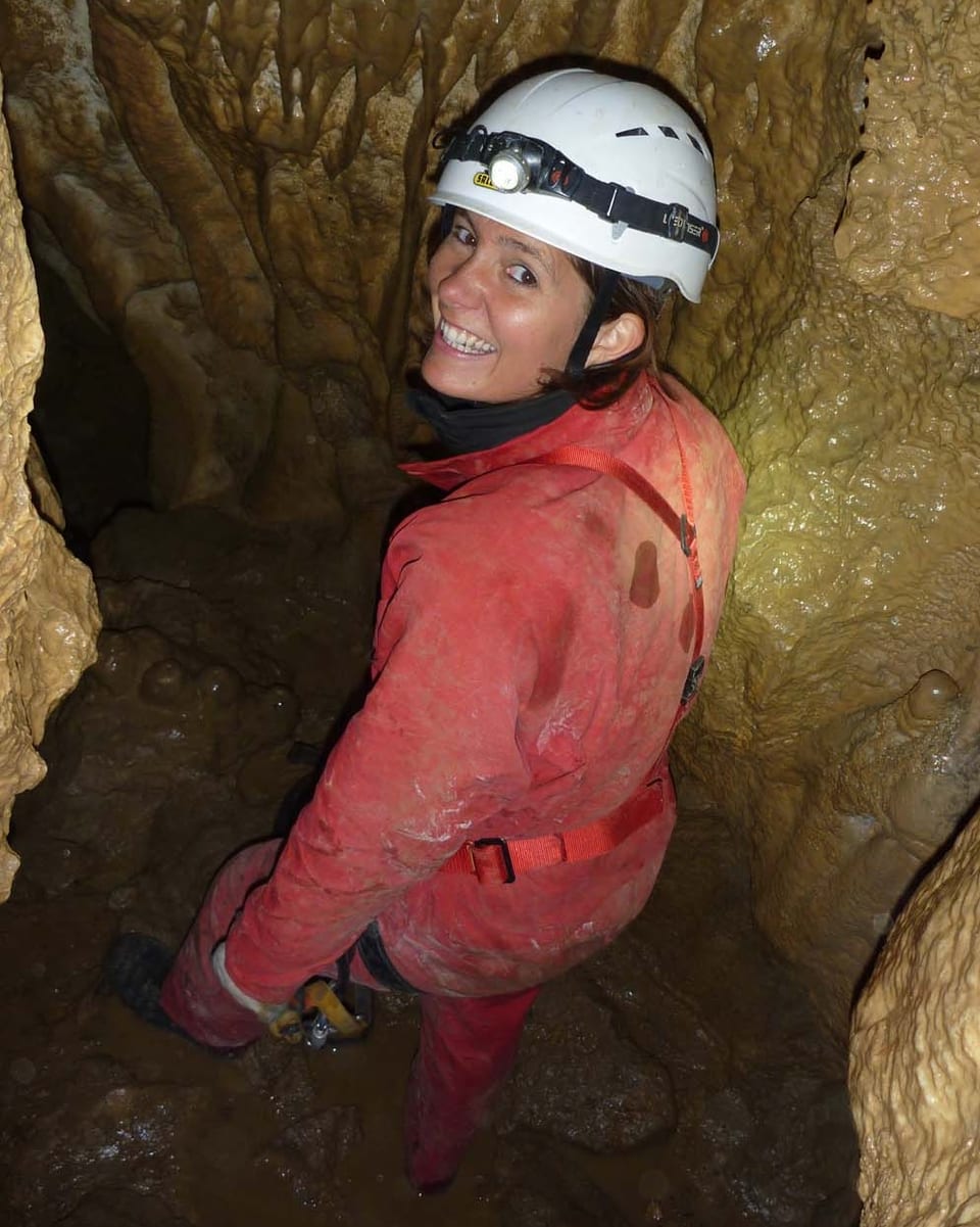 Sarah Allemann mit Helm, Stirnlampe und Übergewand in der Höhle Creux d'Entier.
