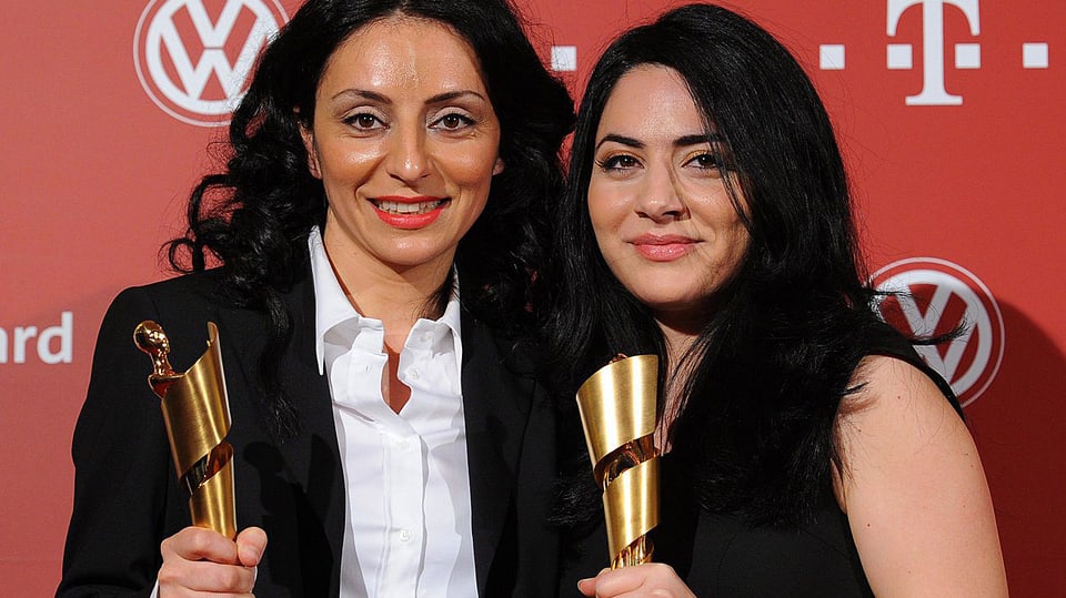 Das Bild zeigt die Schwestern Yasemin und Nesrin Şamdereli mit der Auszeichnung in der Hand.