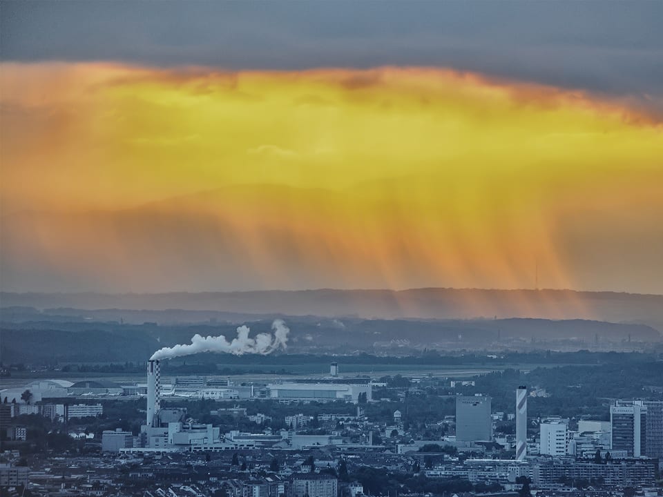 Schornsteine im Vordergrund, Regenschauer im Hintergrund.